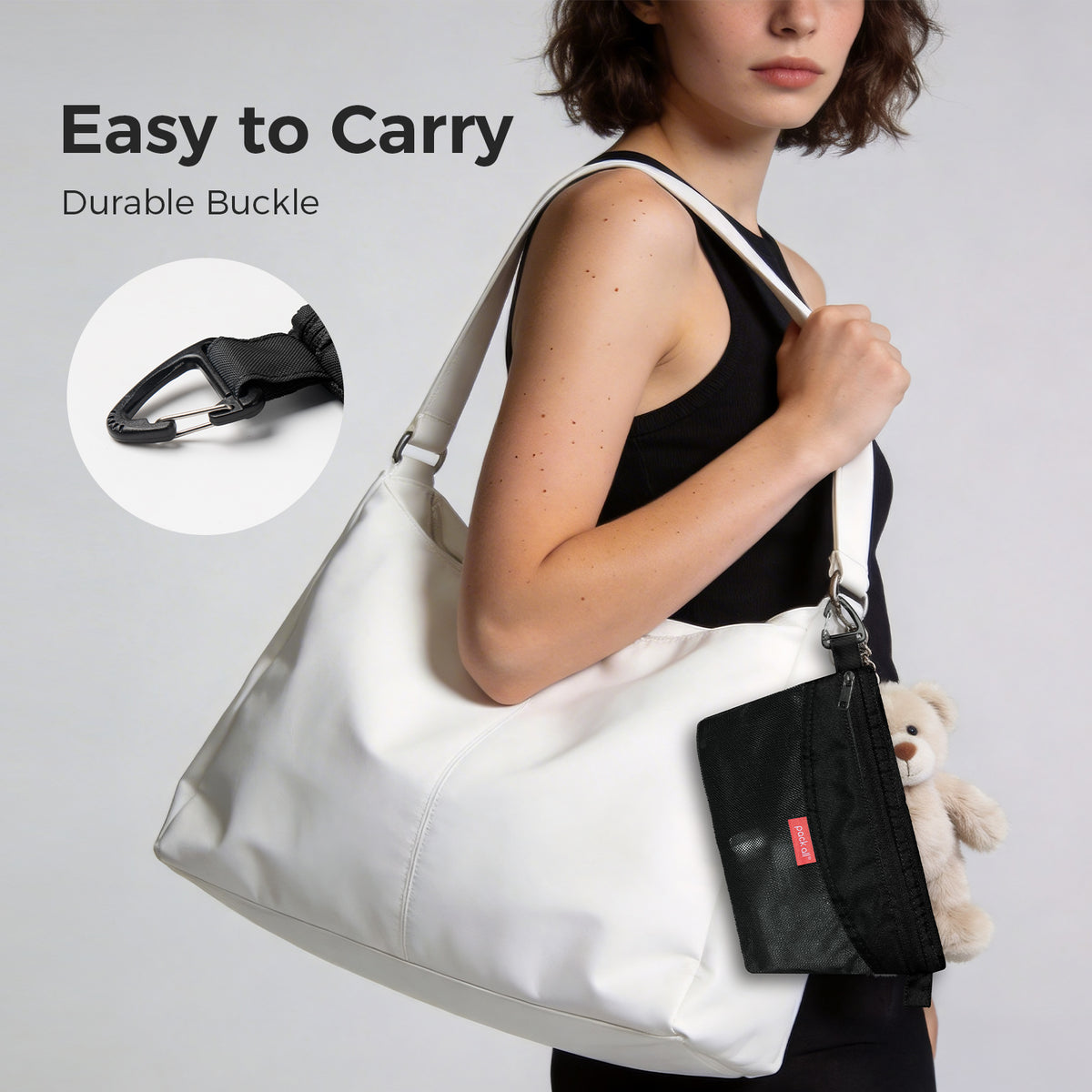 Attach the black small pack all® double-layer daily pouch to a tote bag strap using its clip to keep compact daily essentials within reach.