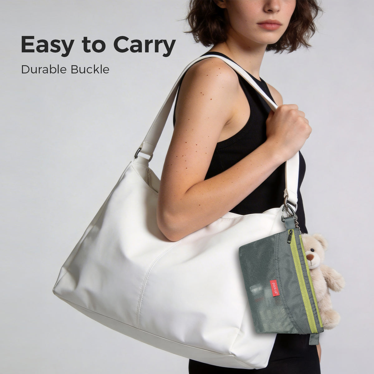 Attach the gray small pack all® double-layer daily pouch to a tote bag strap using its clip to keep compact daily essentials within reach.